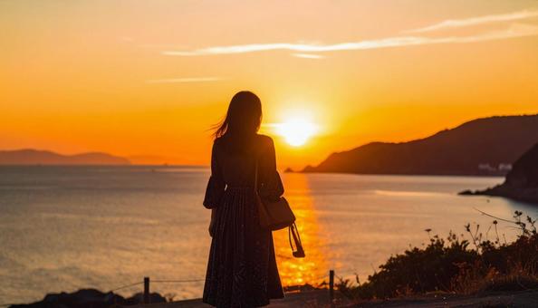夕暮れの海辺にたたずむ日本人女性 夕暮れの海辺にたたずむ日本人女性の写真