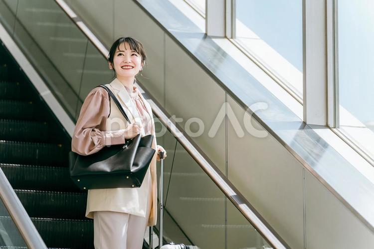 駅のエスカレーターに乗るビジネスウーマン ビジネスウーマン,女性,貿易の写真素材
