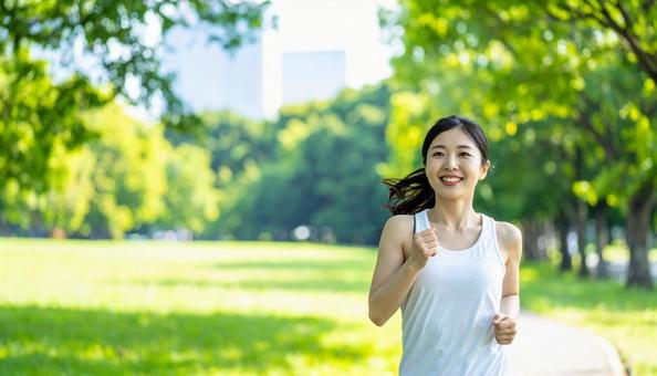 笑顔でジョギングする若い女性 笑顔でジョギングする若い女性の写真