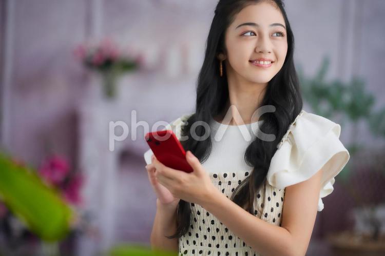 スマホを持ち振り向く女性 女性,スマホ,持つの写真素材