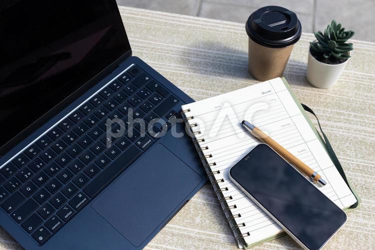 机の上に置かれたパソコンやスマホ ノートパソコン,コーチング,スマートフォンの写真素材