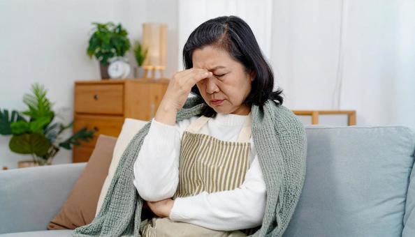 家で体調不良の日本人中年女性 家で体調不良の日本人中年女性の写真