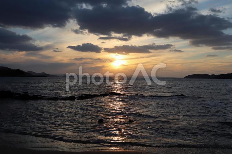雲の合間から海へと沈む夕日を眺めて 夕日,海,雲の写真素材