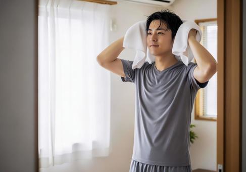 濡れた髪をタオルで拭く男性 濡れた髪をタオルで拭く男性の写真