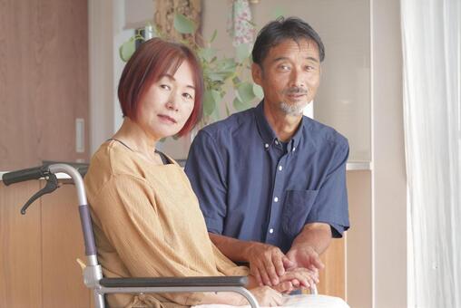 車椅子にすわる妻と寄り添う夫 車椅子,車いす,介護の写真素材