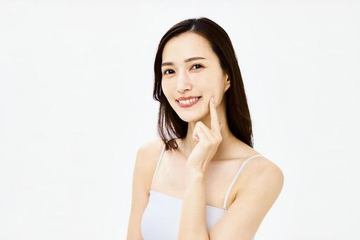 頬を触る笑顔の女性　美容　スキンケア スキンケア,フェイスケア,顔の写真素材