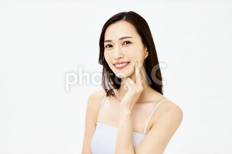 頬を触る笑顔の女性　美容　スキンケア スキンケア,フェイスケア,顔の写真素材