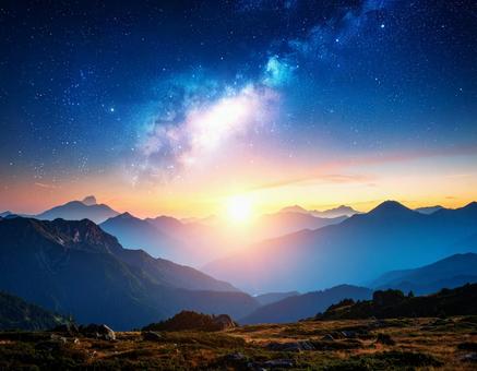 天の川と夜明けの幻想的な空の風景　山2の写真