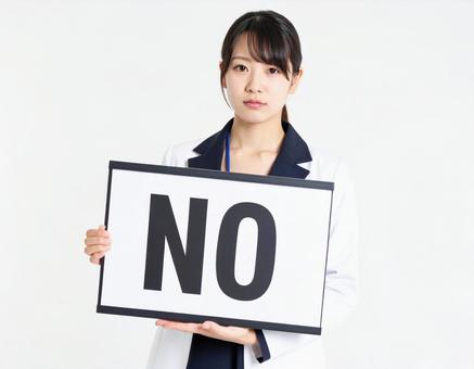 Noと書かれたボードを持つ女性社員 Noと書かれたボードを持つ女性社員の写真