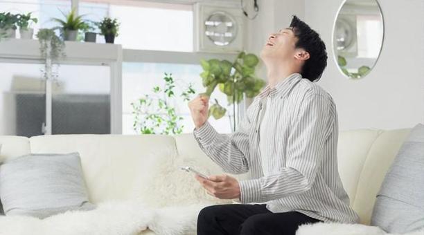 スマホを見てガッツポーズをする男性 ガッツポーズ,男性,スマホの写真素材