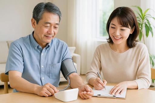 血圧を測定して隣で女性が記録している 血圧を測定して隣で女性が記録しているの写真