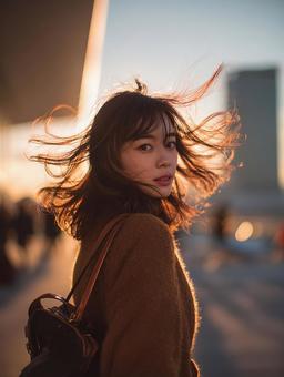 夕暮れ時の女性と髪の動き 夕暮れ時の女性と髪の動きの写真