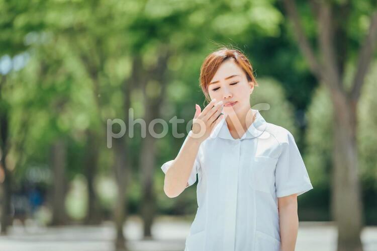 体調不良の白衣の女性 看護師,ナース,暑いの写真素材