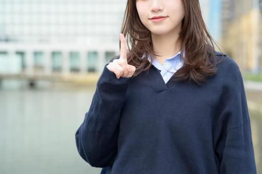 ビル街で指をさす女子高生 ビル街で指をさす女子高生 高校生,女子高生,指さしの写真素材