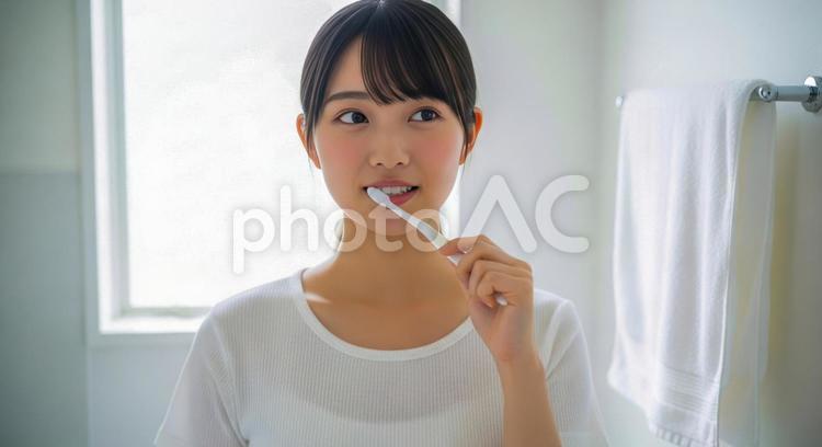 朝の洗面所で歯磨きをする若い女性 女性,歯磨き,朝の写真素材