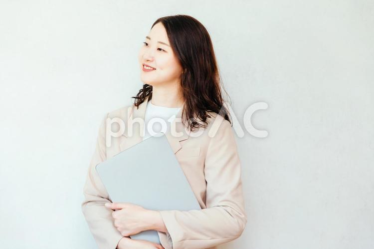 PCを持って笑顔で働く女性 女性,笑顔,パソコンの写真素材