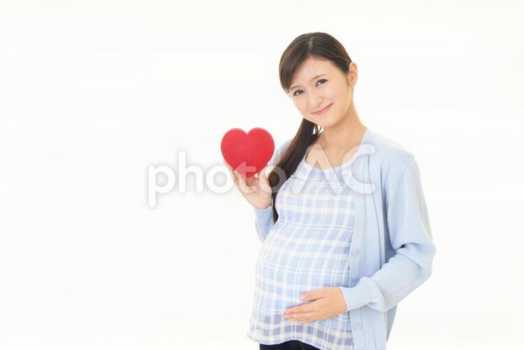 ハートマークを持つ笑顔の妊婦 妊婦,妊娠,女性の写真素材