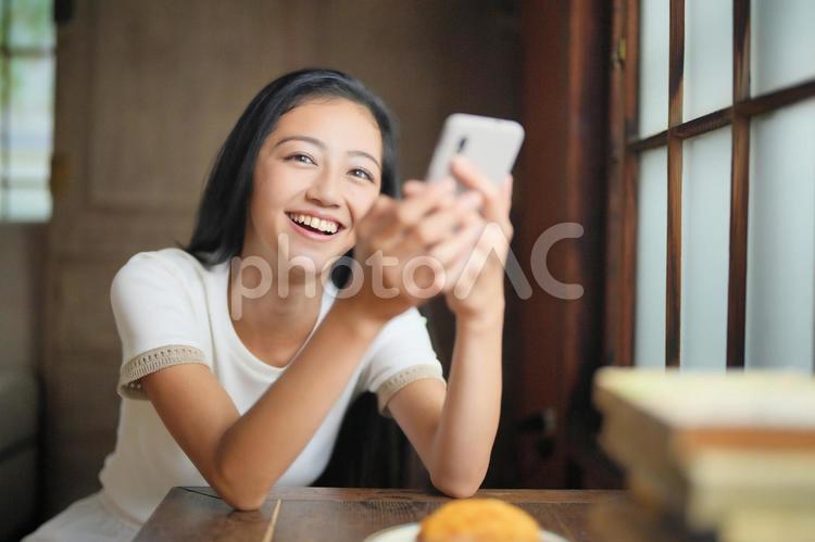 スマホを持ち爆笑する女性 女性,スマホ,持つの写真素材