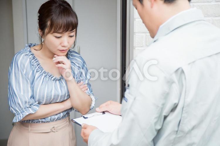 訪問する作業員と女性 玄関,訪問,メンテナンスの写真素材