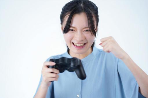 女性がゲームを楽しんで笑顔を見せる 女性,ゲーム,コントローラーの写真素材