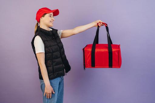 保温ピザバッグを持って立つ女性配達員 配達,フードデリバリー,デリバリーの写真素材