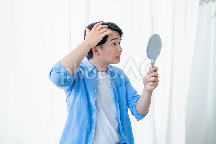 鏡を見るネガティブな男性 手,触る,30代の写真素材