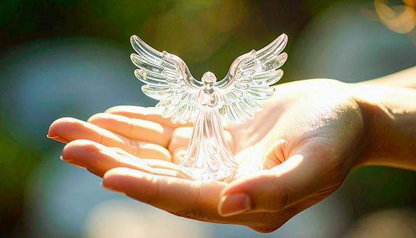 ガラスの天使像を持つ日本人女性の手の写真