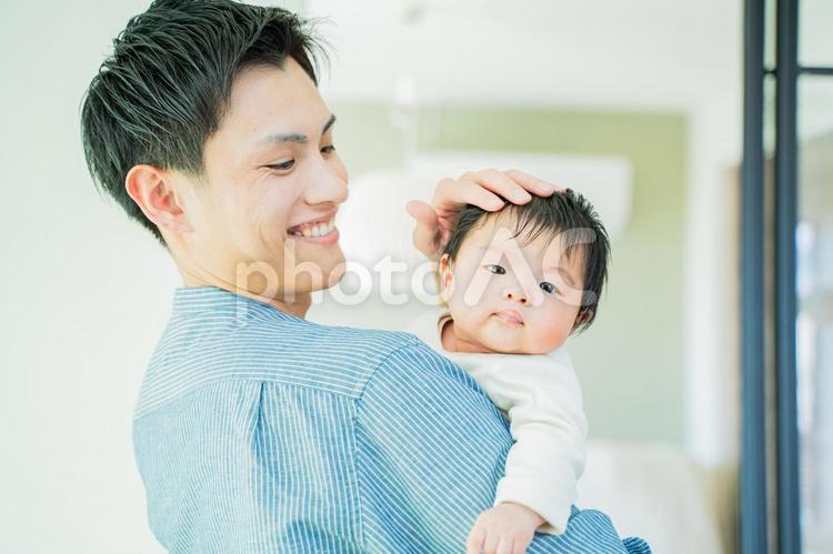 抱っこした赤ちゃんをなでる笑顔のパパ 赤ちゃんのアップ,笑顔,愛情の写真素材