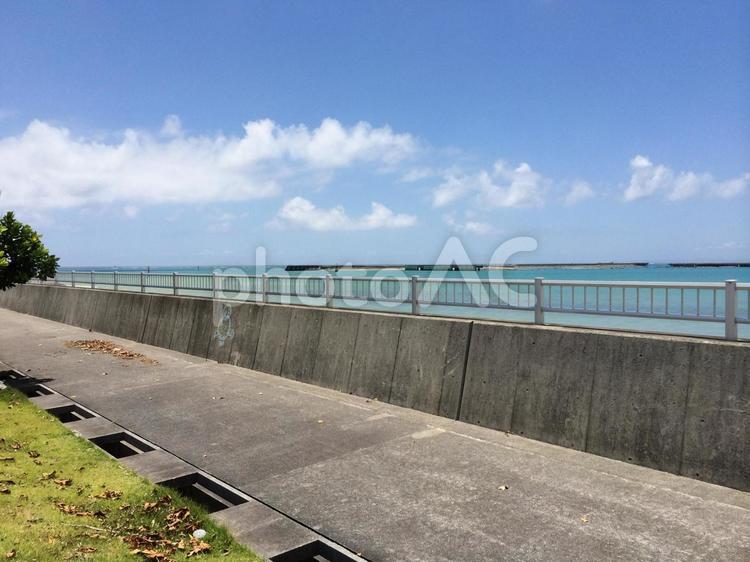 海沿いの道とフェンス、青い空と綺麗な海 フェンス,歩道,シーサイドの写真素材