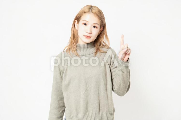 指でポイントを示すセーターを着た若い女性 指,ポイント,女性の写真素材