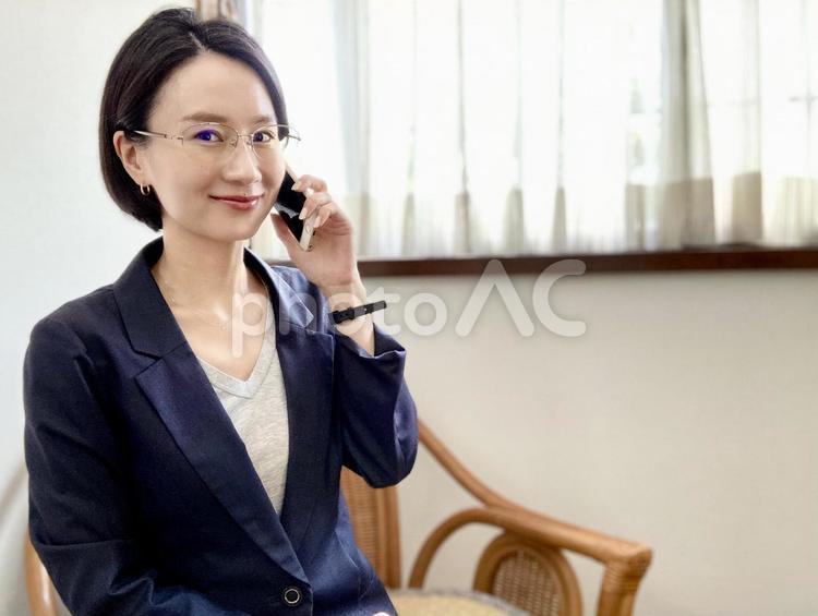 スマホで電話をするスーツ姿の女性 女性,スーツ,スマホの写真素材