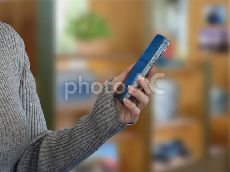 室内でスマホを持つ女性の手 女性,人物,スマホの写真素材