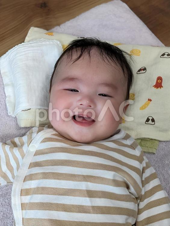 寝転んで微笑む男の子 赤ちゃん,0歳,3ヶ月の写真素材