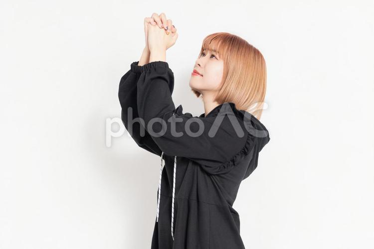 お願いのジェスチャーをするカジュアルな服装の若い女性 お願い,祈る,祈りの写真素材