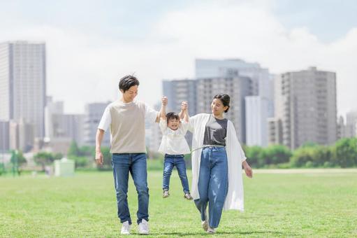 手を繋いで屋外を散歩する親子 手を繋いで屋外を散歩する親子 人物,家族,女性の写真素材