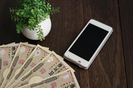 スマートフォンとお金の並び スマートフォンとお金の並び スマートフォン,携帯電話,スマホの写真素材
