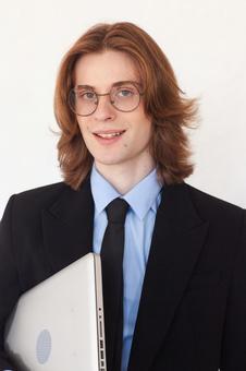 笑顔でパソコンを待つ長髪の外国人男性の写真