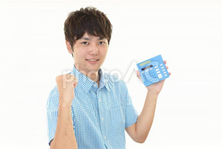 電卓を持ってガッツポーズをする男性 男性,笑顔,計算機の写真素材