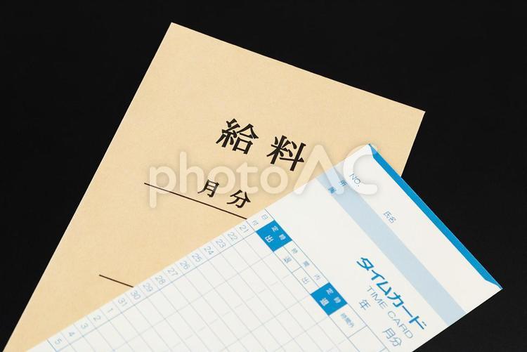 黒背景にタイムカードと給料袋 タイムカード,給料袋,ビジネスの写真素材