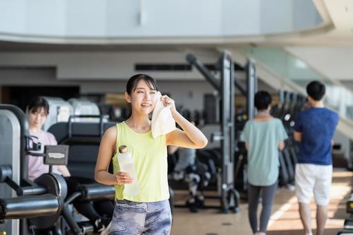 ジムでトレーニングする若い女性 ジム,汗,フィットネスの写真素材