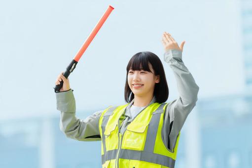 工事現場で交通誘導をする若い女性 女性,ビジネス,作業服の写真素材