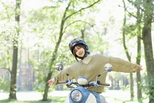 バイクに乗る若い女性 バイクに乗る若い女性 バイク,女性,スクーターの写真素材