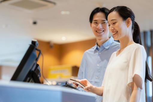 ショッピングをしてモバイル決済をする女性 モバイル決済,ショッピング,買い物の写真素材