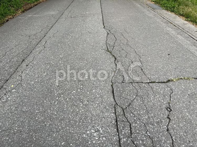 地割れしたアスファルトの道路 地割れ,道路,ひびの写真素材