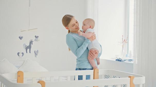 赤ちゃんの顔を見ながら抱っこする笑顔の女性 赤ちゃんの顔を見ながら抱っこする笑顔の女性 女性,赤ちゃん,かわいいの写真素材