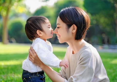 緑の中で遊ぶ、子と母親 緑の中で遊ぶ、子と母親の写真