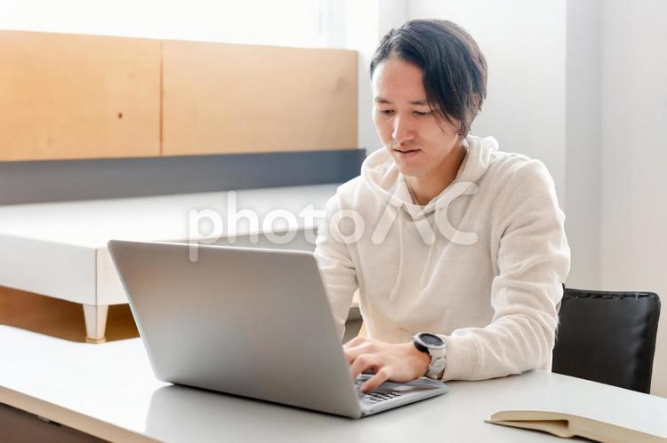 私服男性とPC 男性,パーカー,カジュアルの写真素材