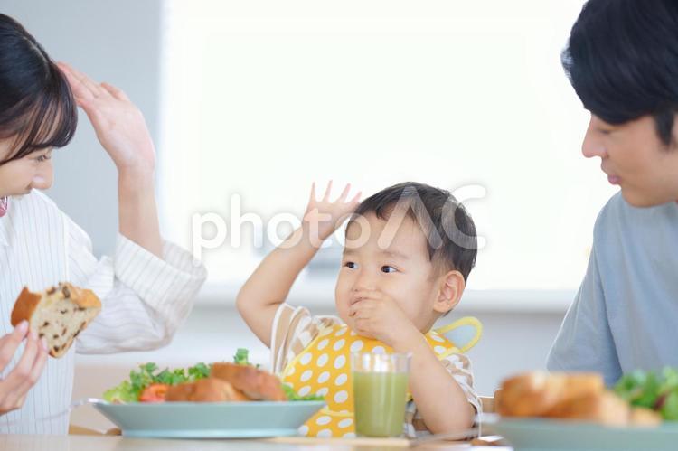 食べながら手をあげる笑顔の母子 親子,食事,手をあげるの写真素材