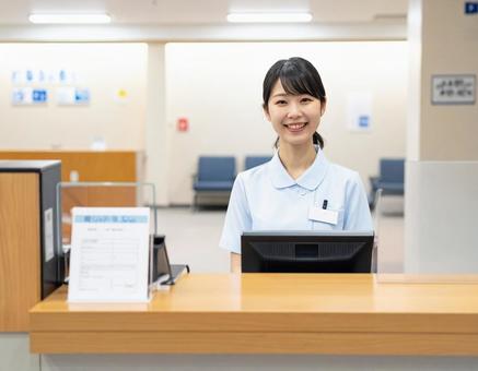 病院の受付コーナーで笑顔で迎える受付嬢 病院の受付コーナーで笑顔で迎える受付嬢の写真