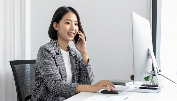 パソコンに向かって話す女性 パソコンに向かって話す女性の写真